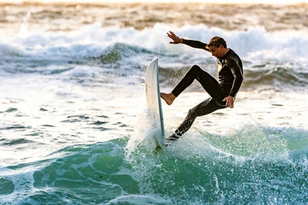 a man in a wet suit riding a surfboard on a wave