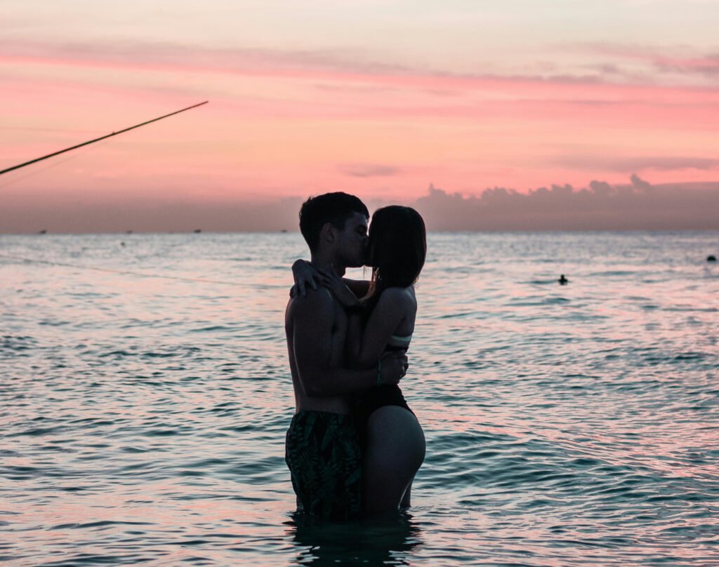 a man and woman kissing in the water